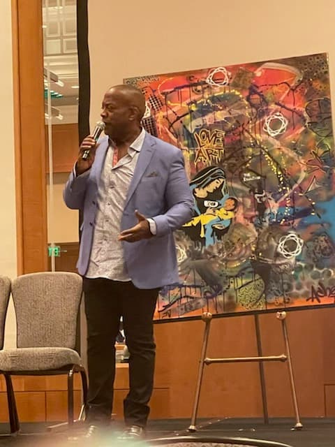 Wali Waiters speaking onstage at a conference